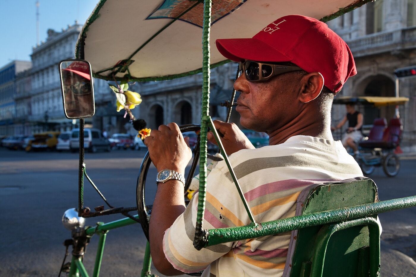 Un conductor de bicitaxi espera clientes en una calle de La Habana