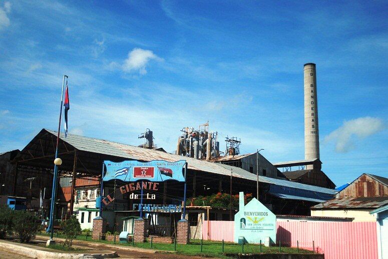 El central azucarero Quintín Banderas con su chimenea y un cartel político en la fachada