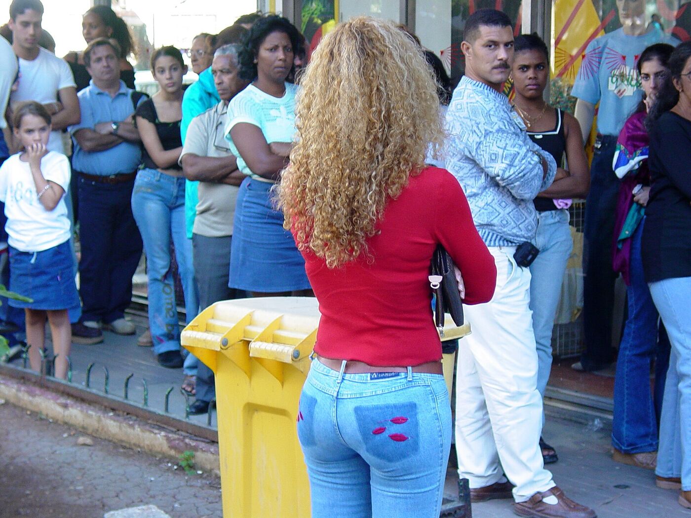 Una cola de gente esperando en una acera de La Habana