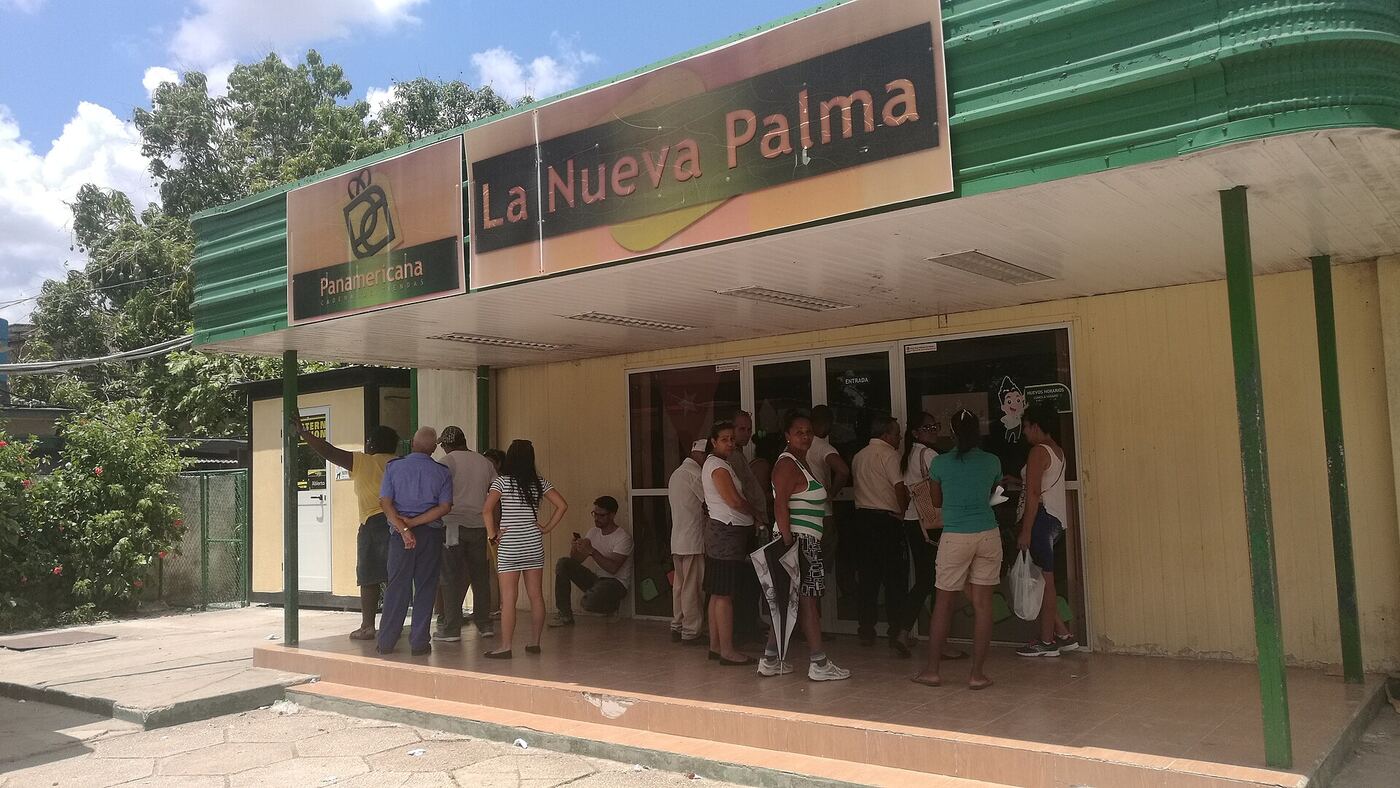 Gente haciendo cola a la entrada de un supermercado en La Habana