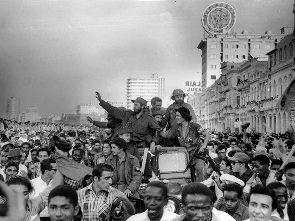 Fidel Castro saluda desde un vehículo rodeado de una multitud en La Habana