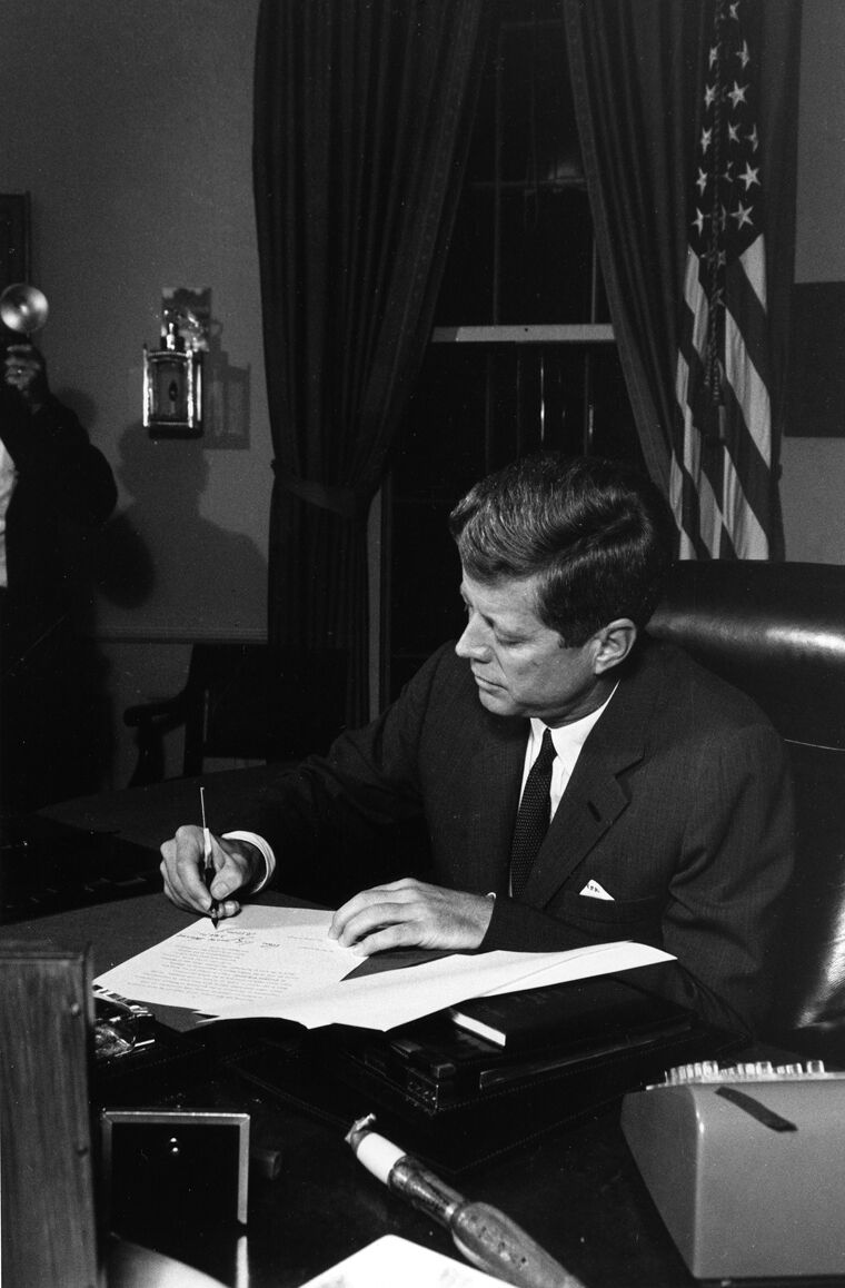 El presidente John F. Kennedy firma en su despacho la proclamación de la cuarentena naval